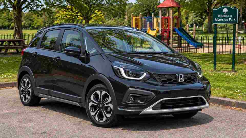 Black Honda Jazz at a park with a playground