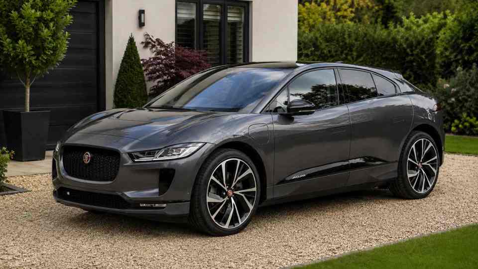 Grey Jaguar I Pace parked on a gravel drive next to grass