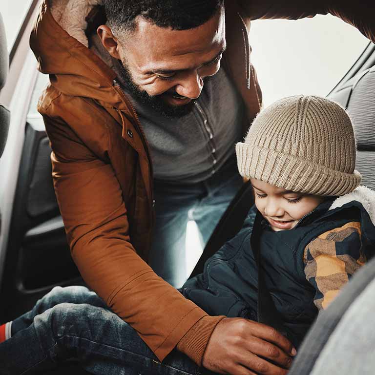 Man Helping Child In Car