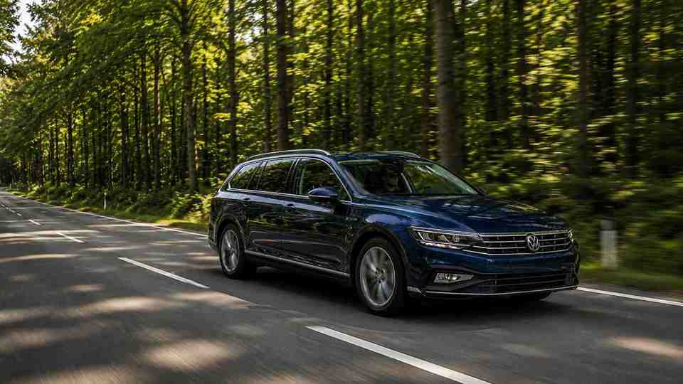 Blue Volkswagen Passat driving through a forrest