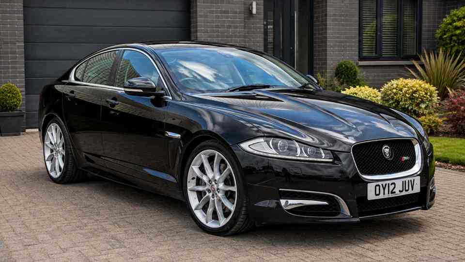 Black Jaguar XF parked on a drive